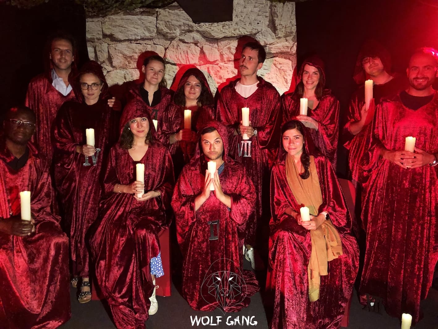 Group in red robes with candles, Wolf Gang